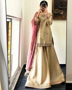 Person wearing a traditional outfit with a pink dupatta in front of a mirror.